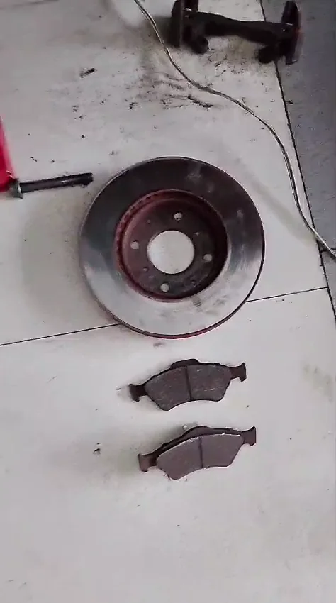 Disco y pastillas delanteras de Honda Fit desmontados para inspección en Ecofrenos Cali.