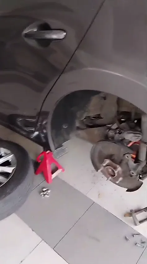 Conjunto de freno trasero abierto en Mazda 3 para retirar disco y pastillas.