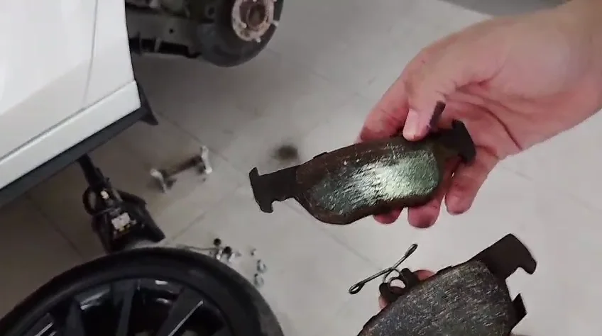 Pastillas de freno retiradas de Mazda 3 con superficie pulida y marcas de trabajo.