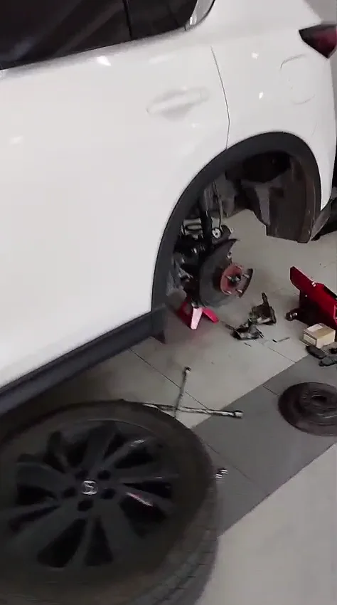 Freno trasero de Mazda CX-5 desmontado para revisar disco, pastillas y mordaza.