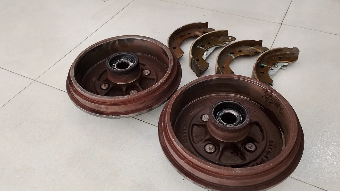 Campanas y bandas traseras retiradas de un Nissan Versa en Cali.