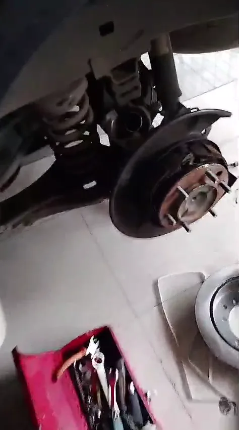 Freno trasero de Toyota Fortuner desmontado para retirar disco y pastillas.