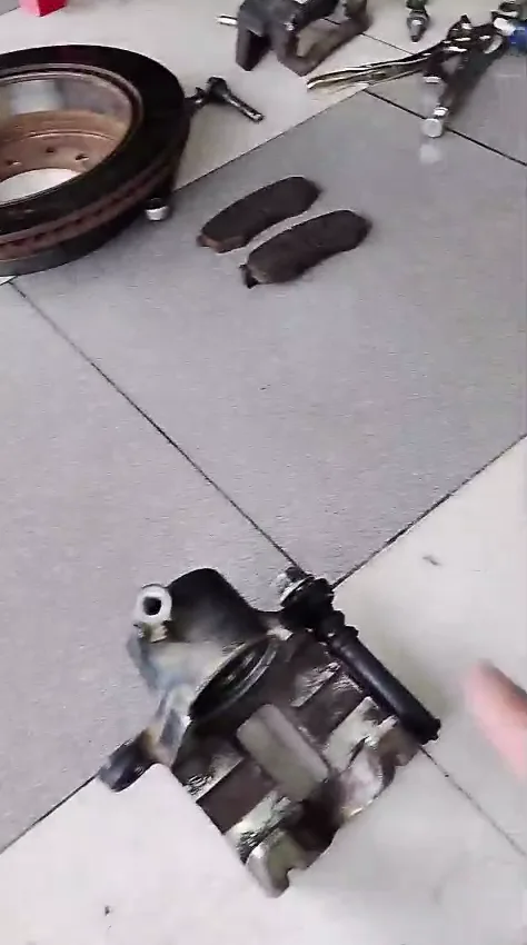 Mordaza y pastillas traseras de Toyota Fortuner revisadas durante el cambio de frenos.