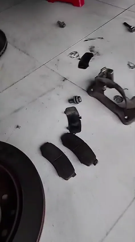 Pastillas y disco trasero retirados de una Toyota Fortuner durante el servicio de frenos.