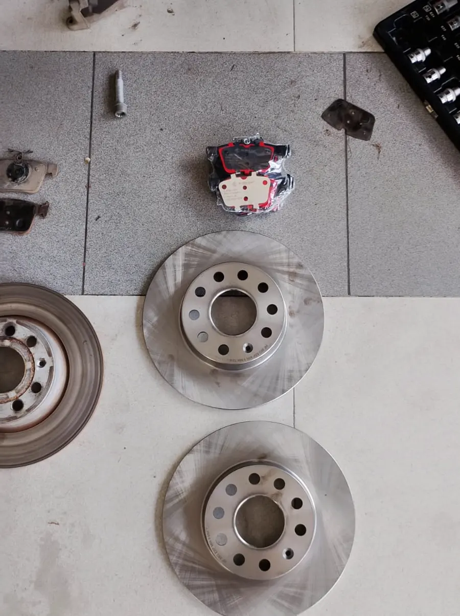 Discos usados y pastillas desgastadas retiradas de Volkswagen Taos por ruido en frenos.